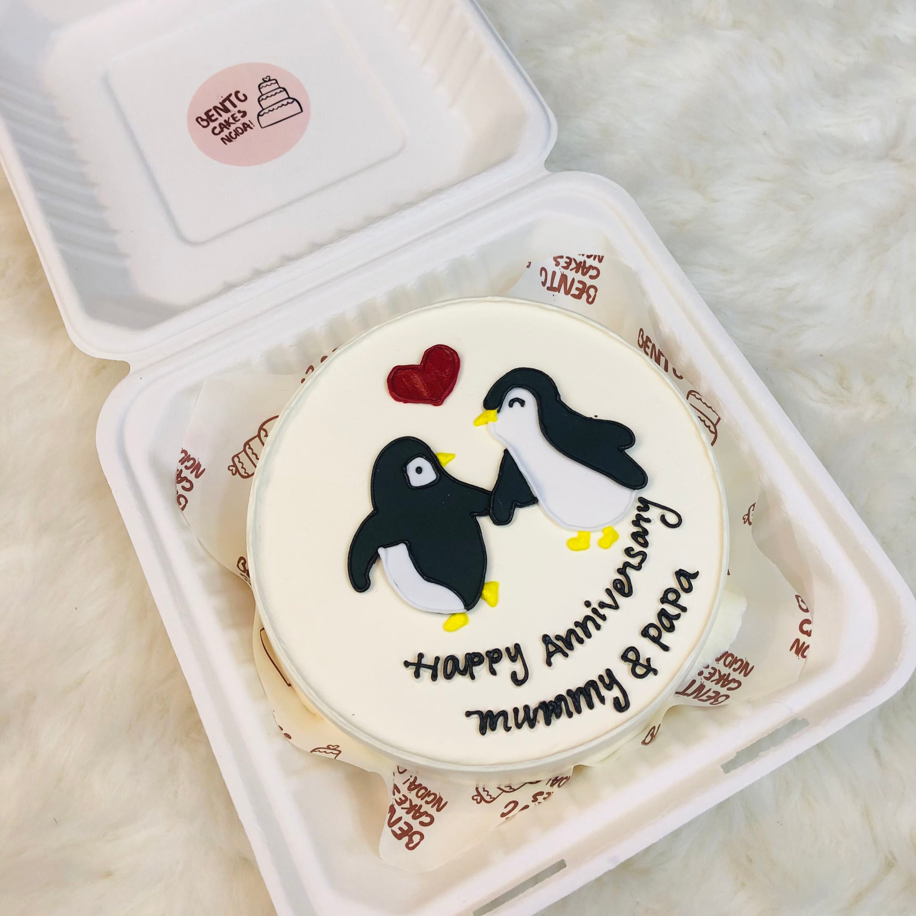 A delightful penguin-themed cake celebrating a happy anniversary, adorned with festive decorations and a joyful design.